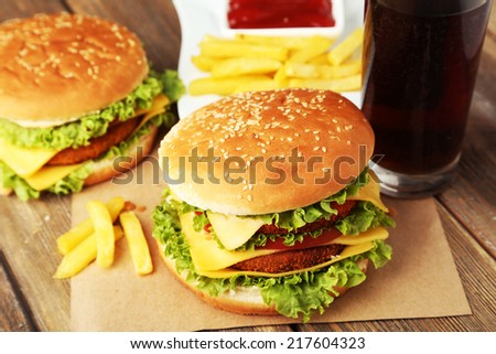 Big burgers on brown wooden background