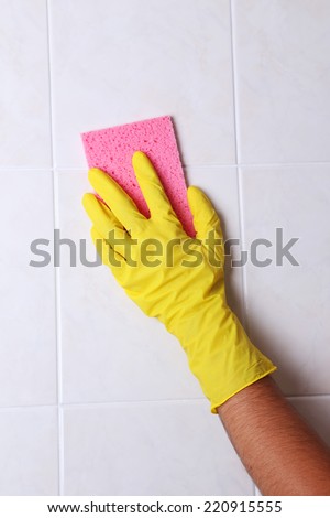 Cleaning kitchen tiles with sponge