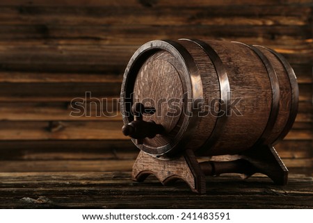 Wooden barrel with iron rings on brown wooden background