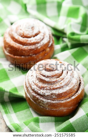 Freshly baked cinnamon buns on green napkin