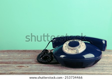 Old retro phone on grey wooden background.Toning