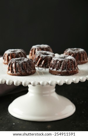 Chocolate bundt cakes on cake stand on black background