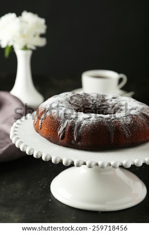 Chocolate bundt cake on cake stand on black background