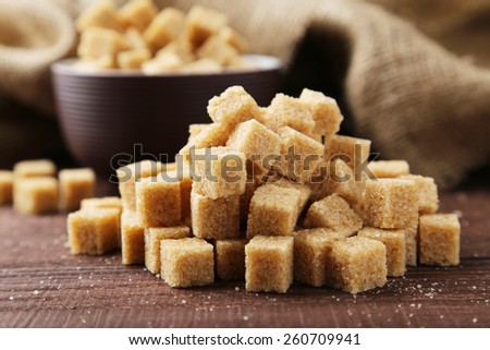 Brown sugar in bowl on brown wooden background