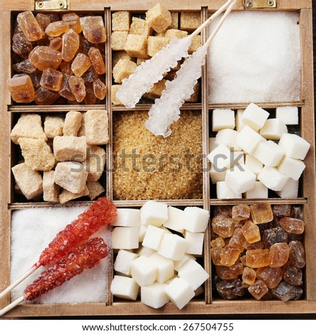 Various kinds of sugar in wooden box on brown wooden background