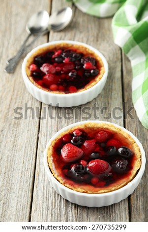 Fresh berry tarts on grey wooden background