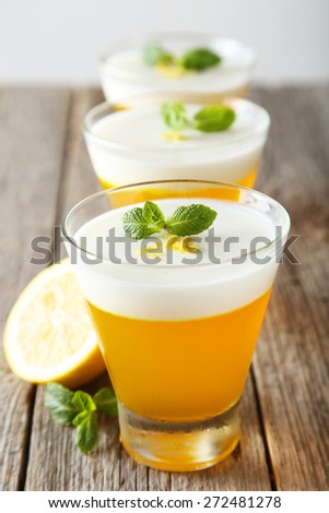 Tasty lemon jelly in glass on grey wooden background