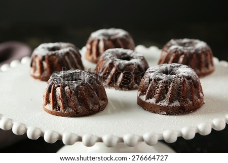 Chocolate bundt cakes on cake stand on black background