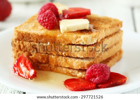 Fresh toast with raspberry and strawberry on white wooden background