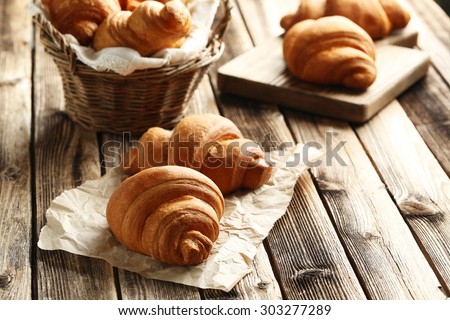 Tasty croissants on brown wooden background