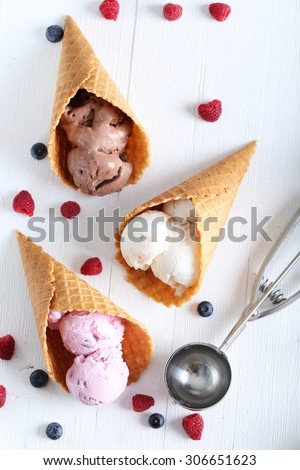 Waffle cones with ice cream on wooden table
