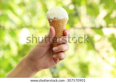 Woman hand holding waffle with ice cream
