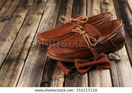 Fashion brown shoes with bow tie on a brown wooden table