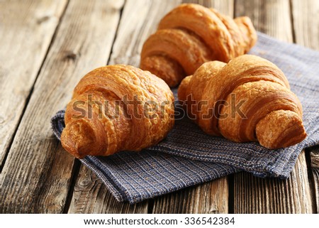 Tasty croissants on brown wooden background