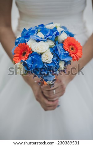 Beautiful wedding bouquet in hands of the newly-married couple on wedding.