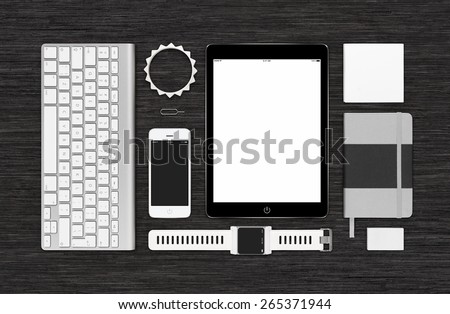 Top view of branding identity technology mockup for design presentation or portfolio on black desk. Template includes tablet computer, smart watch, smartphone, keyboard, bracelet, notebook, reminder.