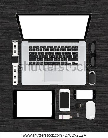 Top view of technology mockup for design presentation or portfolio on black desk surface. Consists of laptop, tablet computer, smart watch, smartphones, computer mouse, glasses.