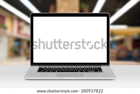 Front view of modern laptop mockup with white blank screen on the office desk. Office space on the background.