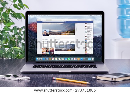 Facebook Timeline in user profile on the Apple Macbook Pro Retina screen that is on office wooden desk. Facebook is the most popular social network in the world. Varna, Bulgaria - May 31, 2015.