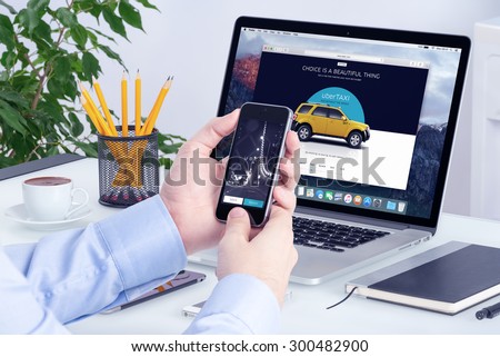 Uber application on the Apple iPhone display and desktop version of Uber on the Apple Macbook Pro screen. Uber multi devices concept. All gadgets in full focus. Varna, Bulgaria - May 29, 2015.