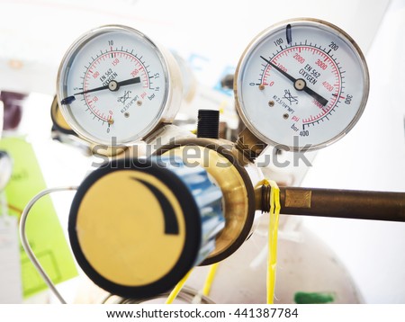 Close up gauges and valve on nitrogen gas cylinder in laboratory
