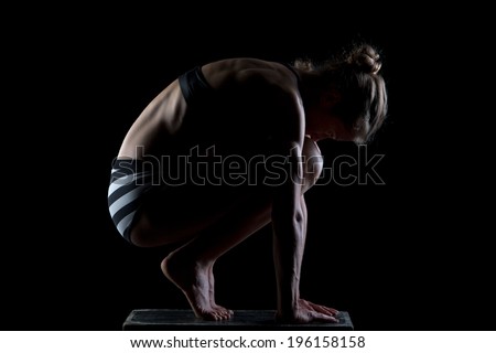 Beautiful sporty woman is working out on black background