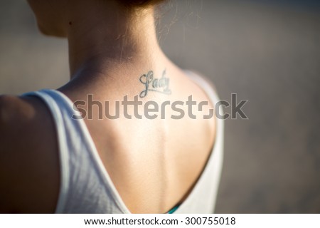 female back with a tattoo in evening lighting