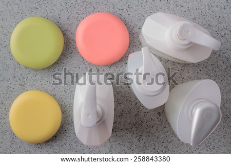 close up of a cosmetics white bottles plastic on grey background bottle and soap-dish with soap amid plastic containers for cosmetics
