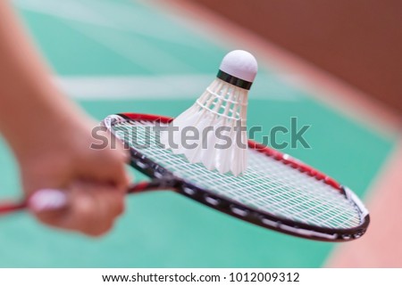 kid holding badminton racket and shuttlecock  in badminton court.