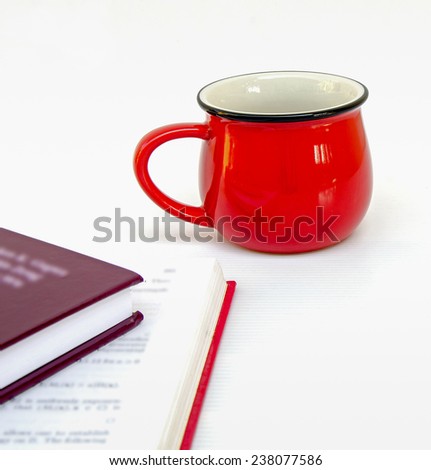 red cup of coffee and two books on white background