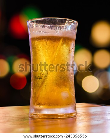 glass of beer with bokeh bar scene in the background