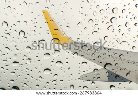 Water drop and droplet on mirror bright with wing of an airplane flying