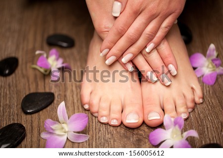 Relaxing pink manicure and pedicure with a orchid flower