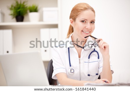 Portrait of a smiling physician working in her office