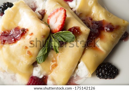 Crepes with strawberry and blackberry stuffed with cheese with marmalade and jam. Top view
