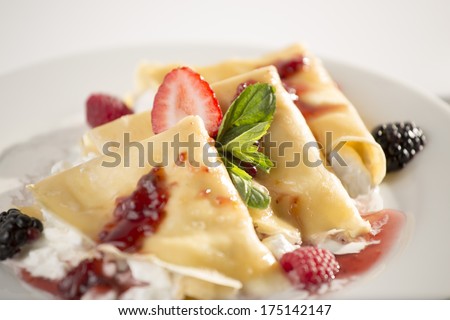Crepes with strawberry and blackberry stuffed with cheese with marmalade and jam. Close up