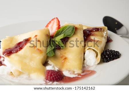 Crepes with strawberry and blackberry stuffed with cheese with marmalade and jam.Side close up