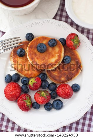 Cheese pancakes with fresh blueberry and strawberry, top view