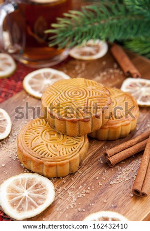 Moon cakes and tea with lemon and cinnamon around. Chinese mid autumn festival food.