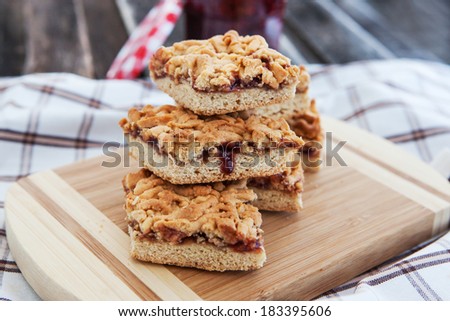 Homemade jam filled bar cookies on wooden board