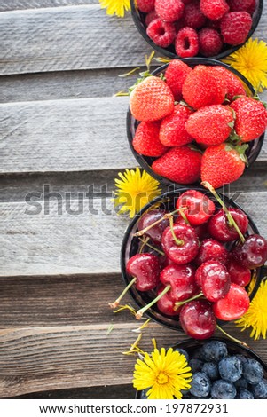 Fresh cherry, strawberry, blueberry and raspberry on wooden table, copy space