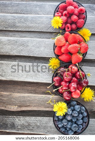 Fresh cherry, strawberry, blueberry and raspberry on wooden table, copy space