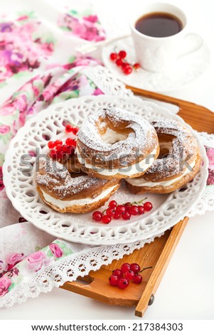 Cream puff rings (choux pastry) decorated with fresh red currant