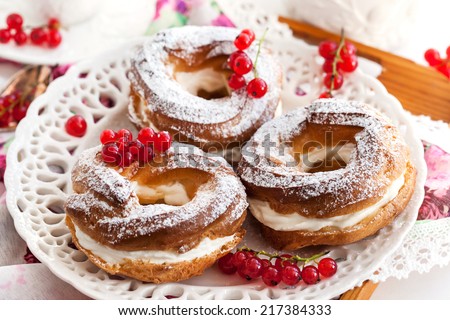 Cream puff rings (choux pastry) decorated with fresh red currant