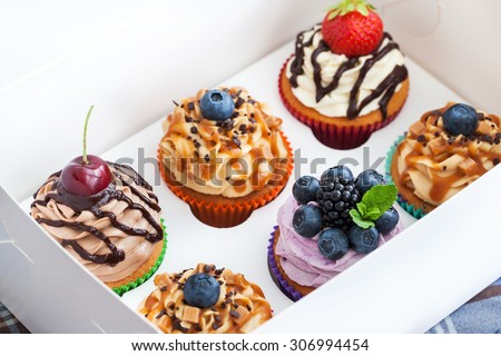 Set of different delicious cupcakes in a paper box