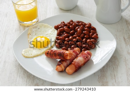 Full English cooked breakfast with bacon, sausage, fried egg and baked beans