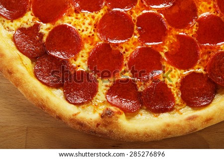 Pizza pepperoni on a wooden background