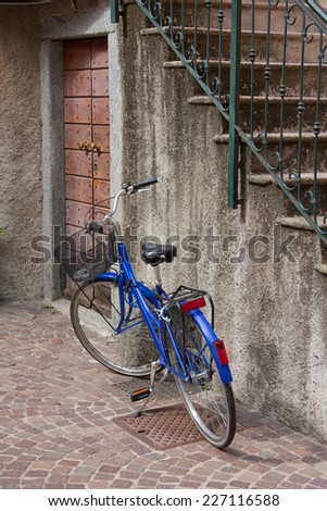 Blue bicycle with a basket by the stairs