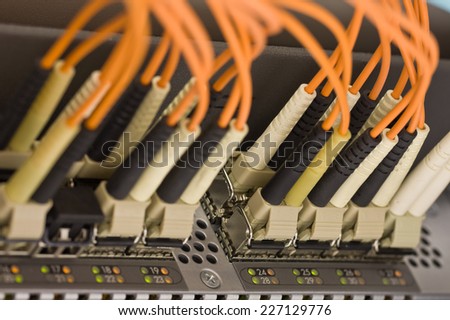 Optical communication cables plugged into the high speed network router