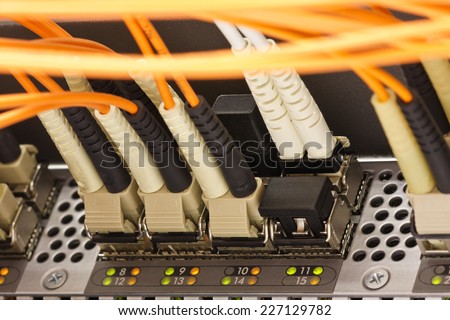 Optical communication cables plugged into the high speed network router